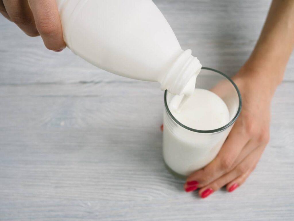 Kefir na odchudzanie. Jak kefir może pomóc w redukcji wagi? 6 Dłoń z szklanką kefiru. Obrazek w artykule Kefir na odchudzanie. Jak kefir może pomóc w redukcji wagi?