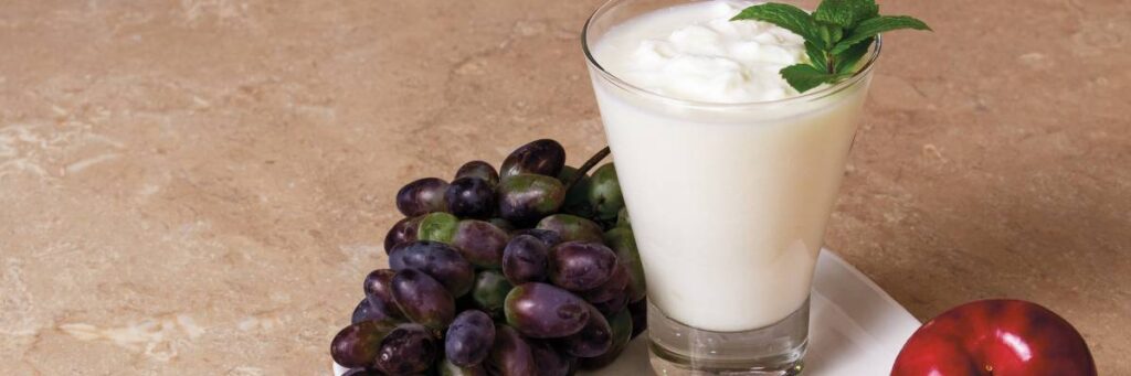 Na co dobry jest kefir? Odkrywamy jego sekretne właściwości 2 Szklanka kefiru i ciemne winogrona. Obrazek w artykule Na co dobry jest kefir? Odkrywamy jego sekretne właściwości