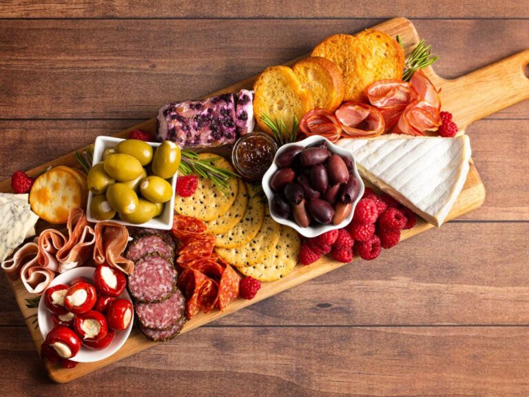 Deska z serami, wędlinami i oliwkami. Obrazek w artykule Przykładowa deska serów - inspiracje na różne okazje