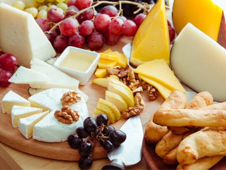 Deska z serami i owocami. Obrazek w artykule Podpowiadamy, jak powinna wyglądać idealna deska serów. Poznaj sposoby serwowania serów