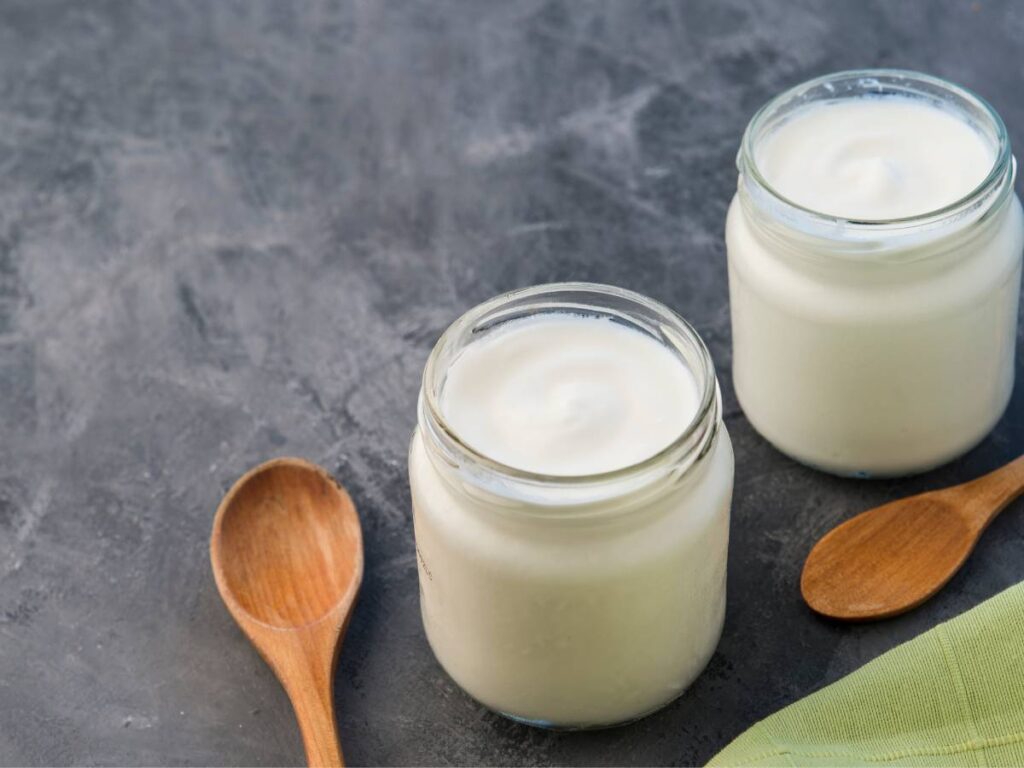 Analizujemy, czy jogurt naturalny jest zdrowy. Odkryj fakty i mity 7 Jogurt w słoiczkach i łyżeczka. Obrazek w artykule Czy jogurt naturalny jest zdrowy