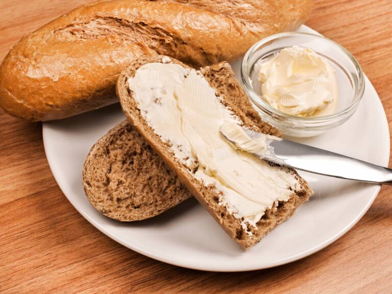 Masło z bagietką. Obrazek w artykule Zastanawiamy się, czy masło można mrozić? Odkryj wady i zalety mrożenia masła
