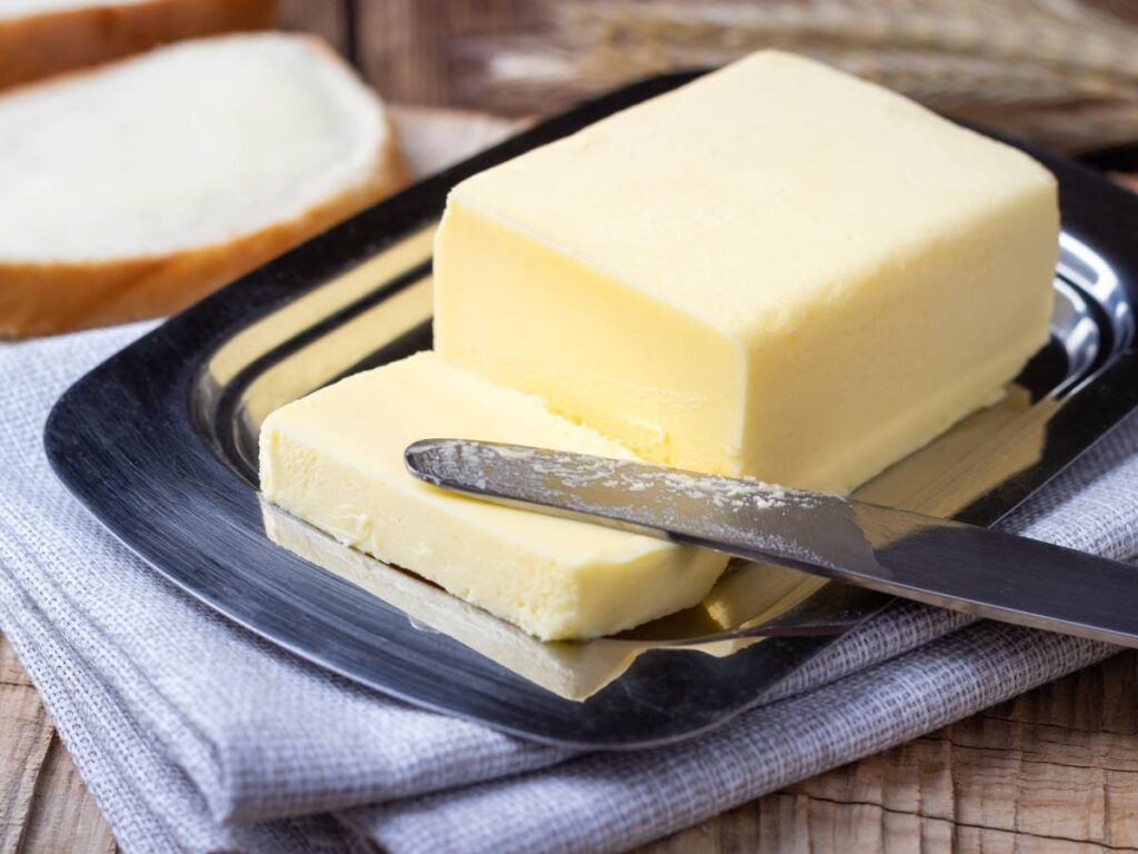 Sprawdzamy, czy masło podnosi cholesterol. Odkryj fakty o wpływie masła na zdrowie 7 Kostka masła na maselniczce. Obrazek w artykule Sprawdzamy, czy masło podnosi cholesterol. Odkryj fakty o wpływie masła na zdrowie