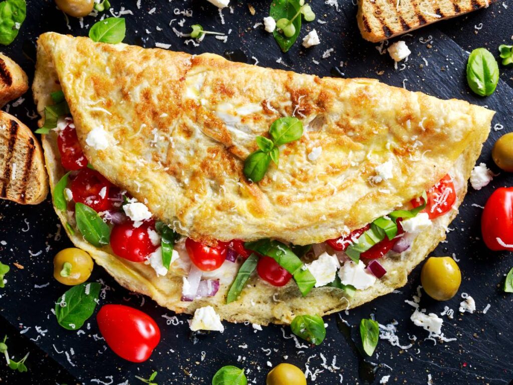 Opowiadamy, jak się robi omlet krok po kroku. Wypróbuj smakowity przepis 4 Omlet z pomidorkami i fetą. Obrazek w artykule Opowiadamy, jak się robi omlet krok po kroku
