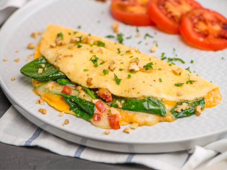 Omlet z dodatkiem szpinaku. Obrazek w artykule 3 pomysły na pyszny omlet z serka wiejskiego. Odkryj pyszne opcje śniadaniowe