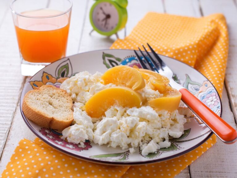 Miska z twarożkiem i owocami. Obrazek w artykule Z czym najlepiej łączyć serek wiejski na śniadanie? Poznaj słone i słodkie opcje